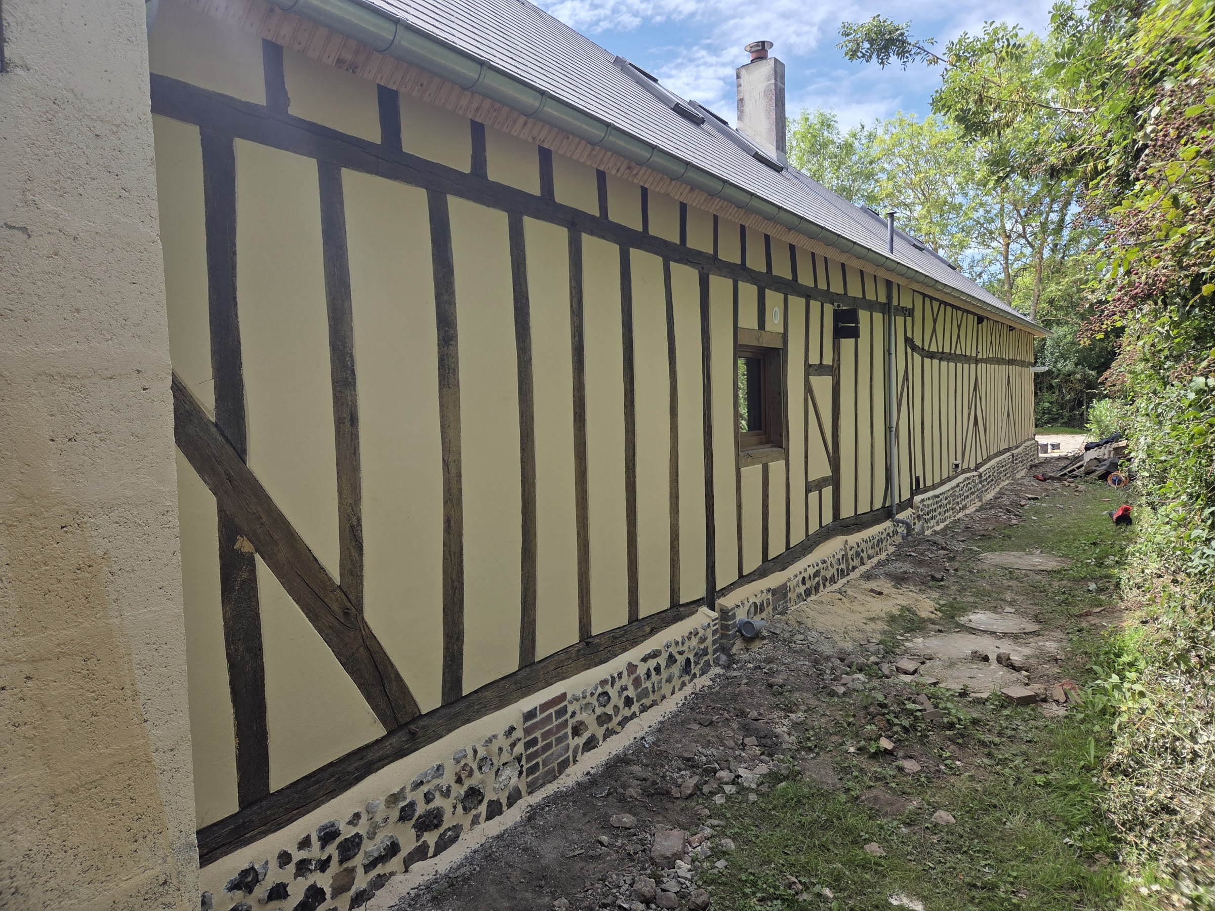 Façade en colombage restaurée, ossature en chêne et soubassement en silex