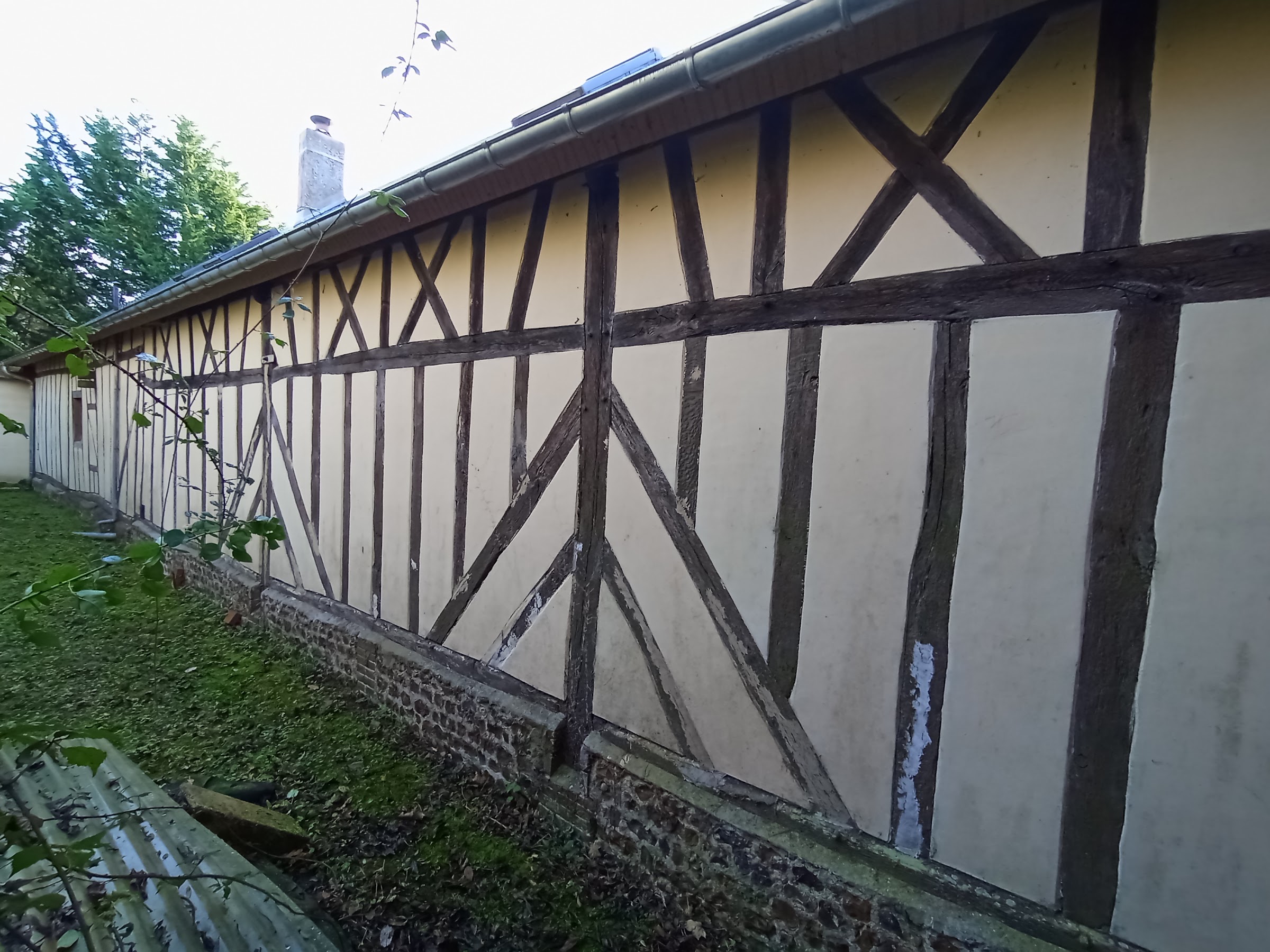 Soubassement en silex et brique restauré au pied d'un colombage